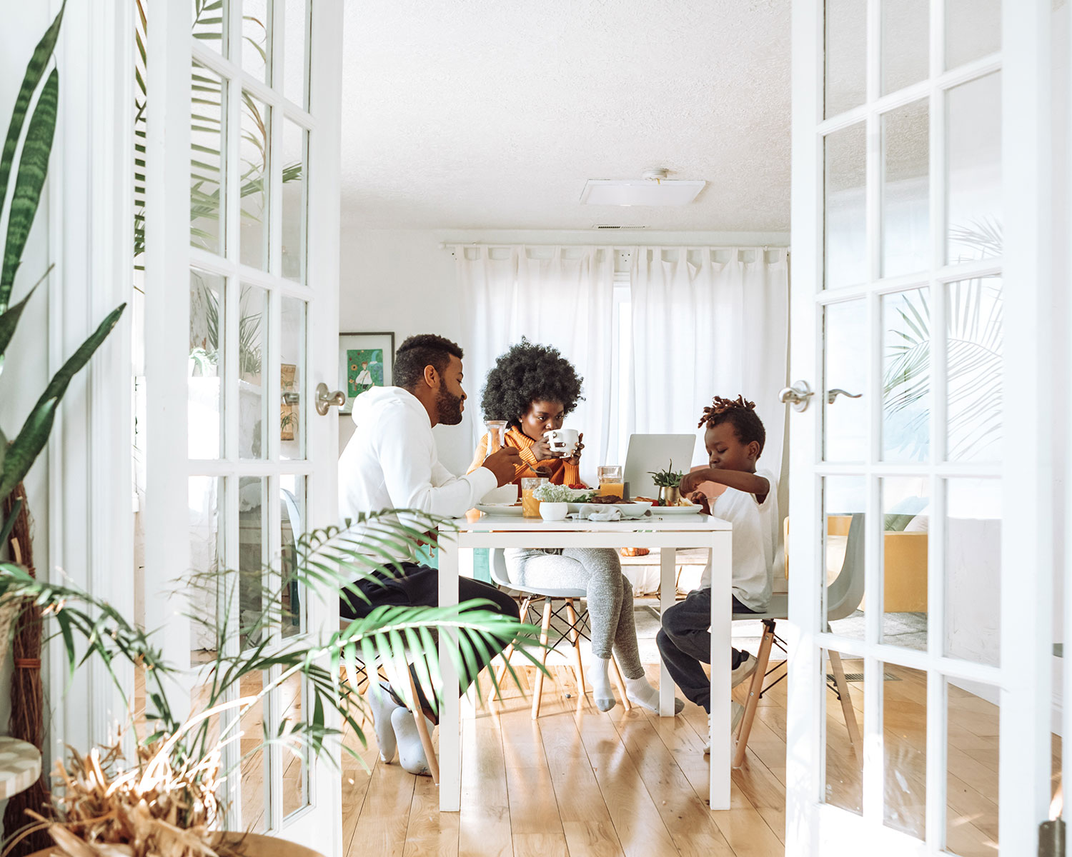 Family enjoys breakfast together sitting at the kitchen table.