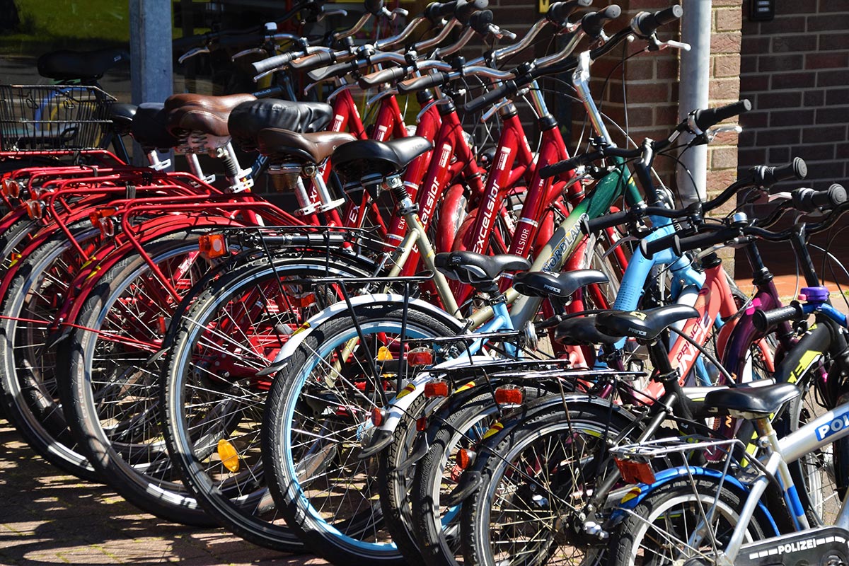 Group of colorful bikes lean against a building.