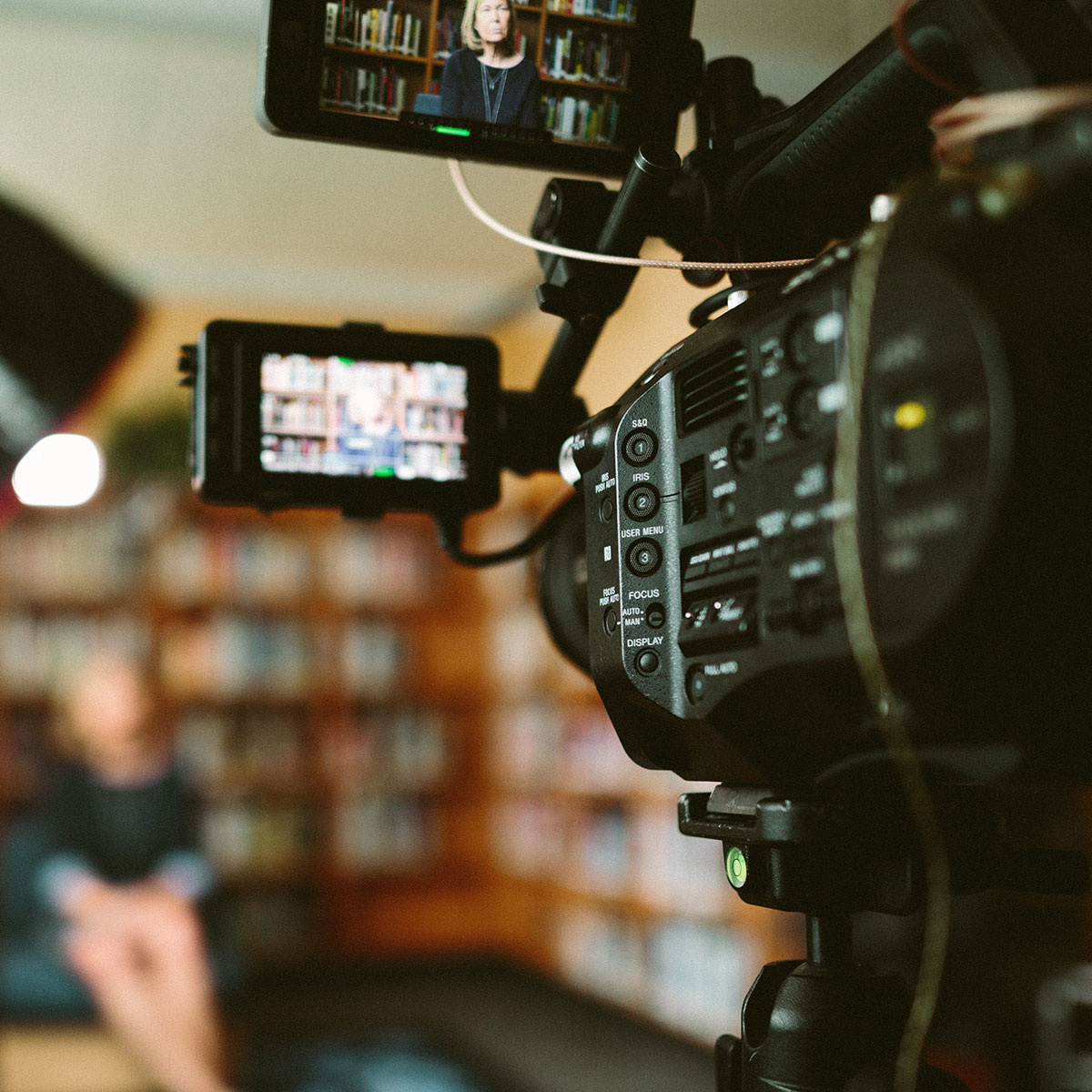 Close-up of news camera recording someone being interviewed.