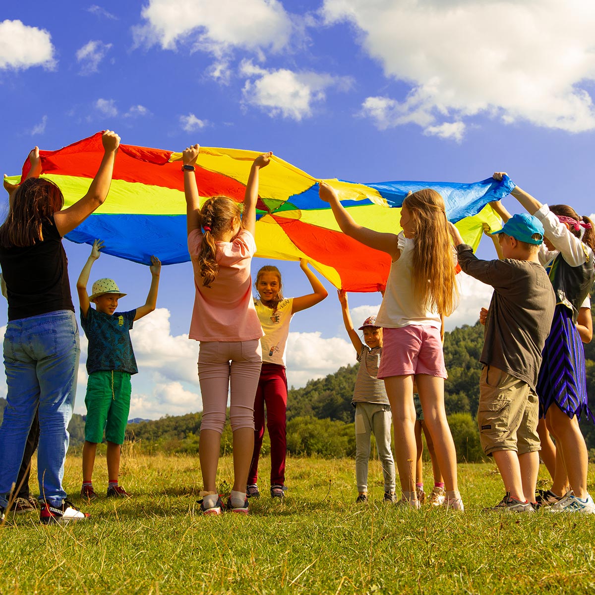 Kids play outside with a colorful flag.