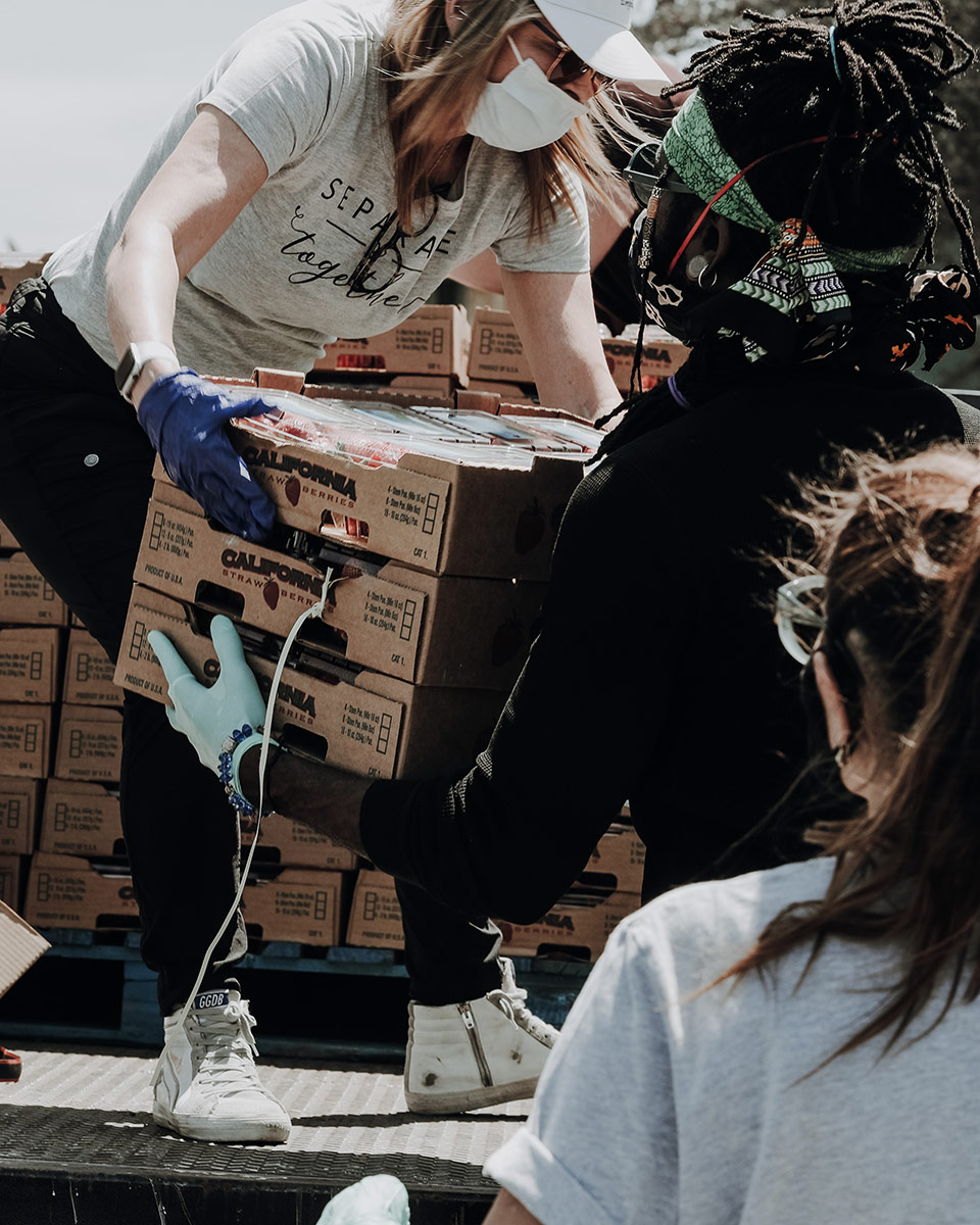 Volunteers work together to move boxes off a truck.