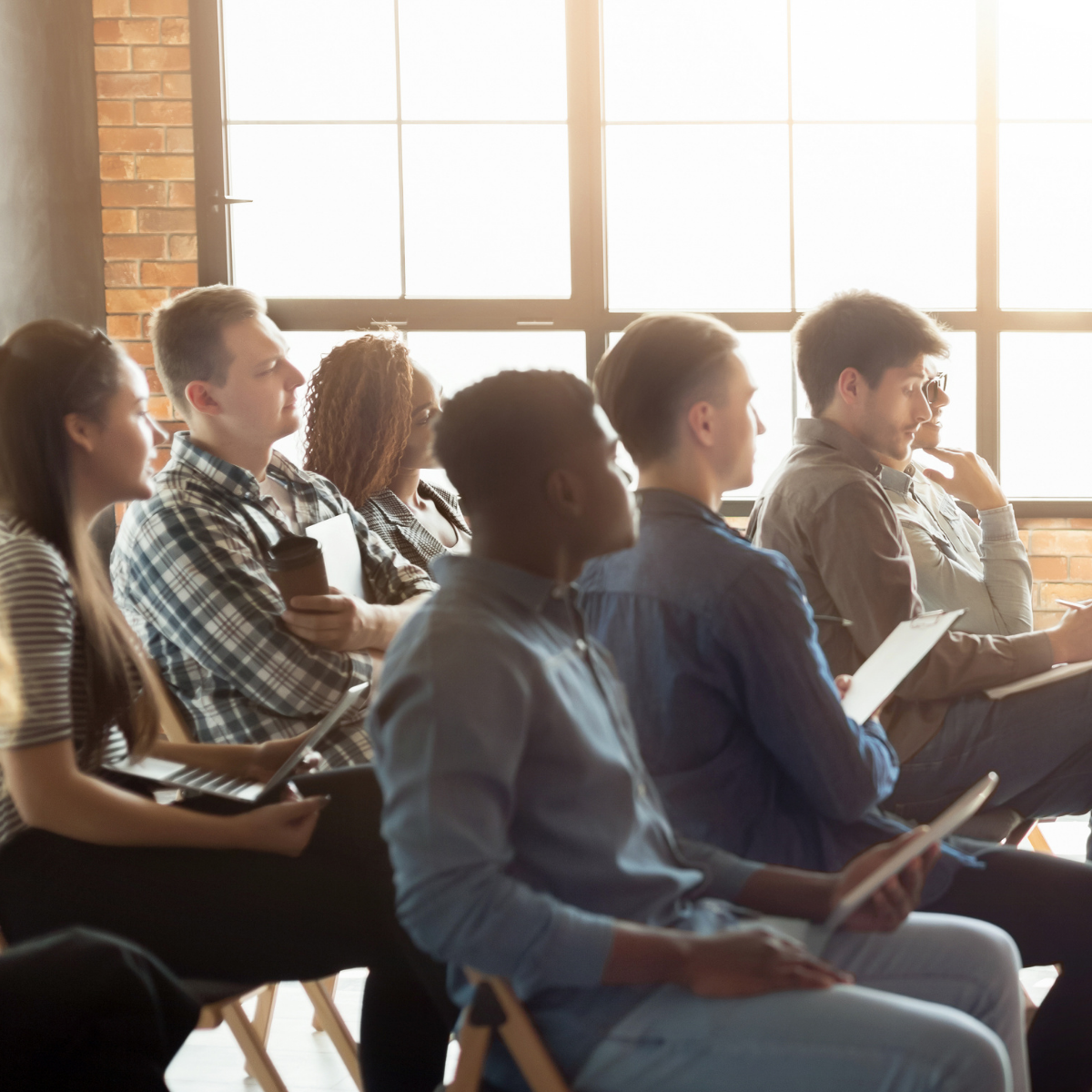 Group of adults in class listen to a teacher.