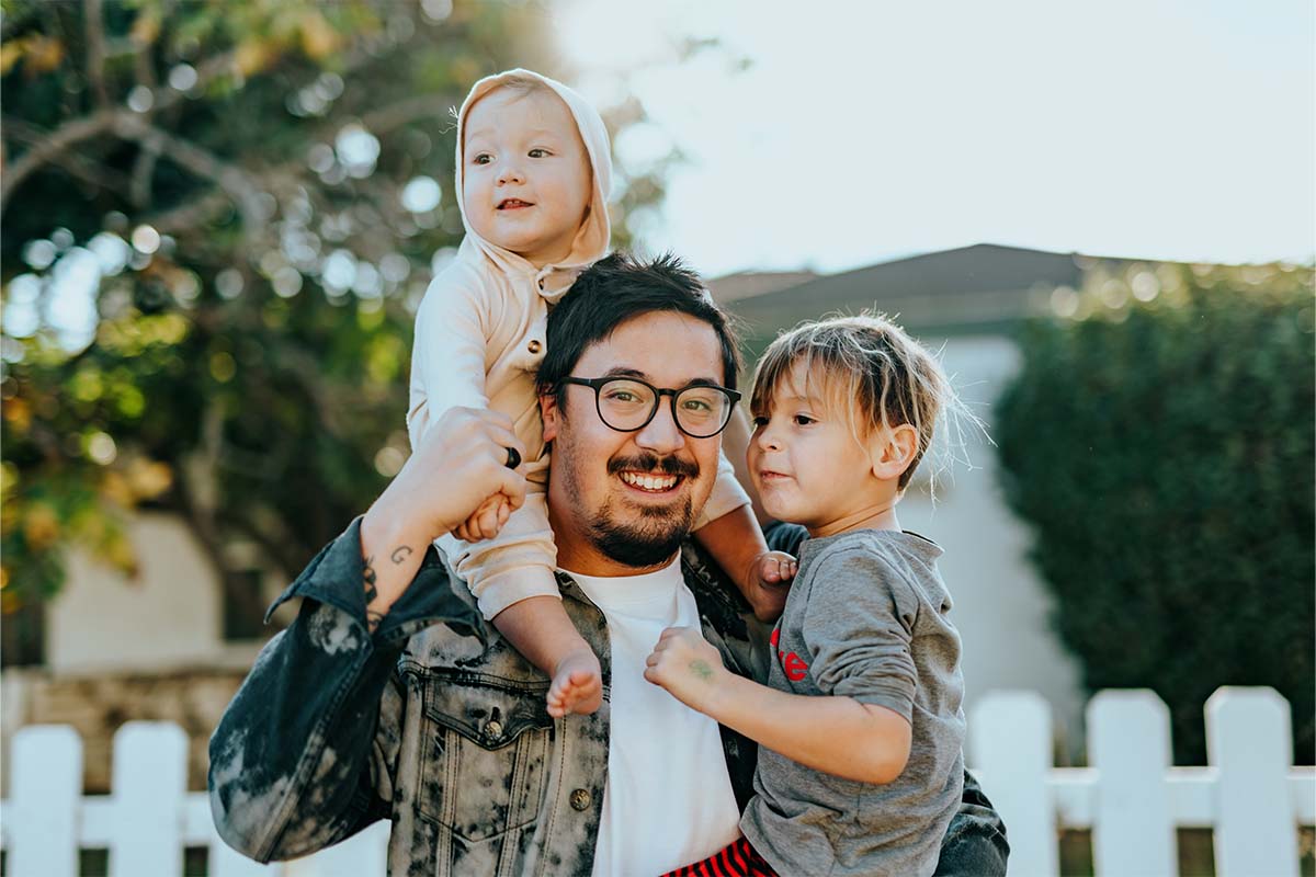 Father poses with two children.