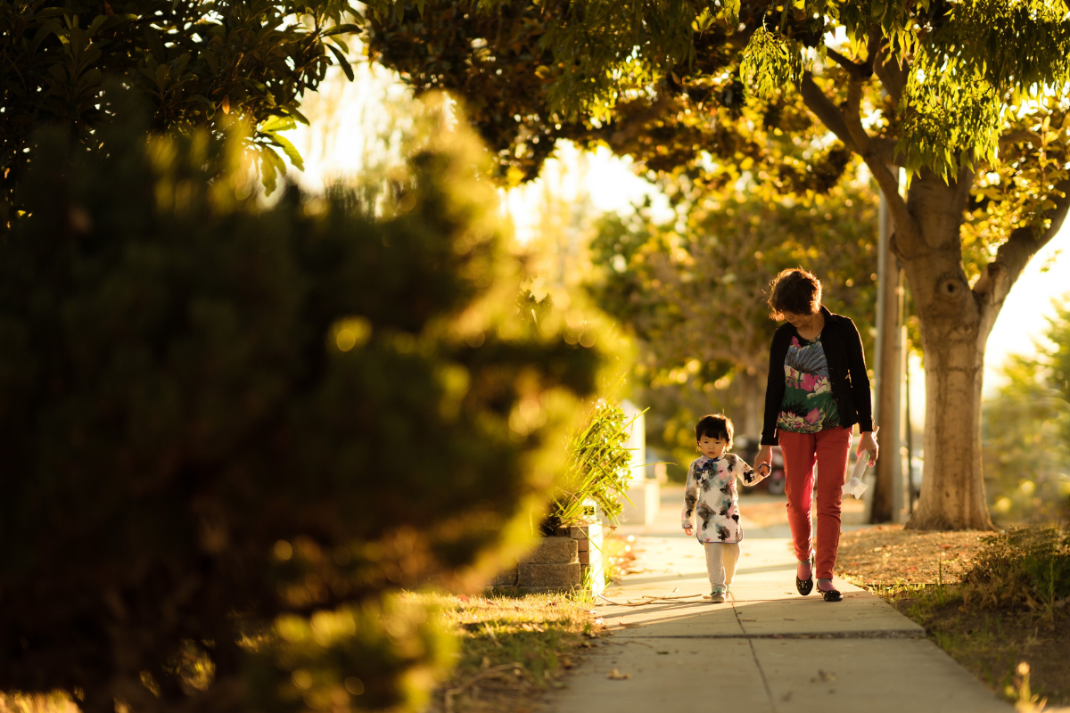 A mother walks her child down the street.