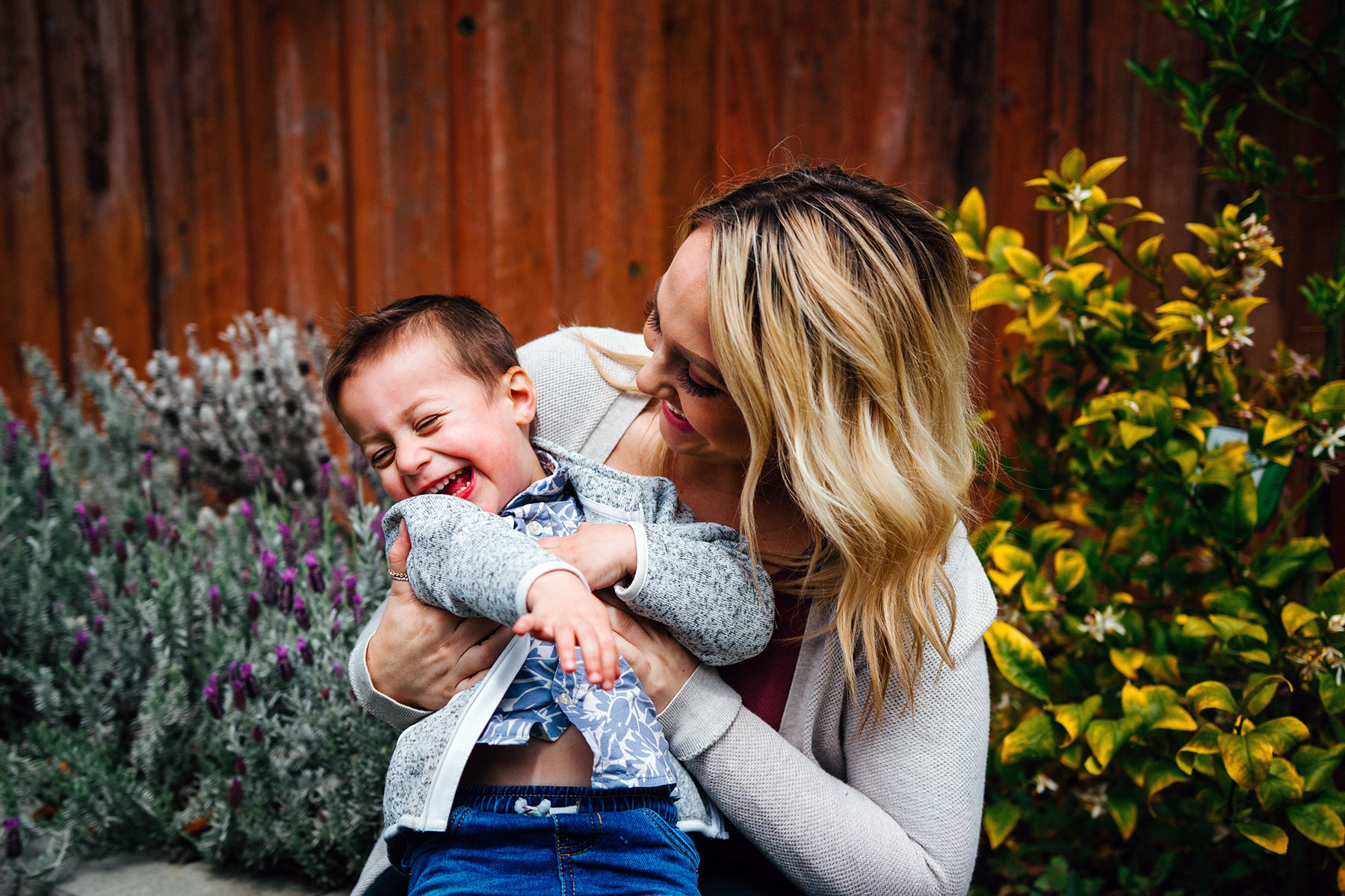 A mom hugs and laughs with her son.